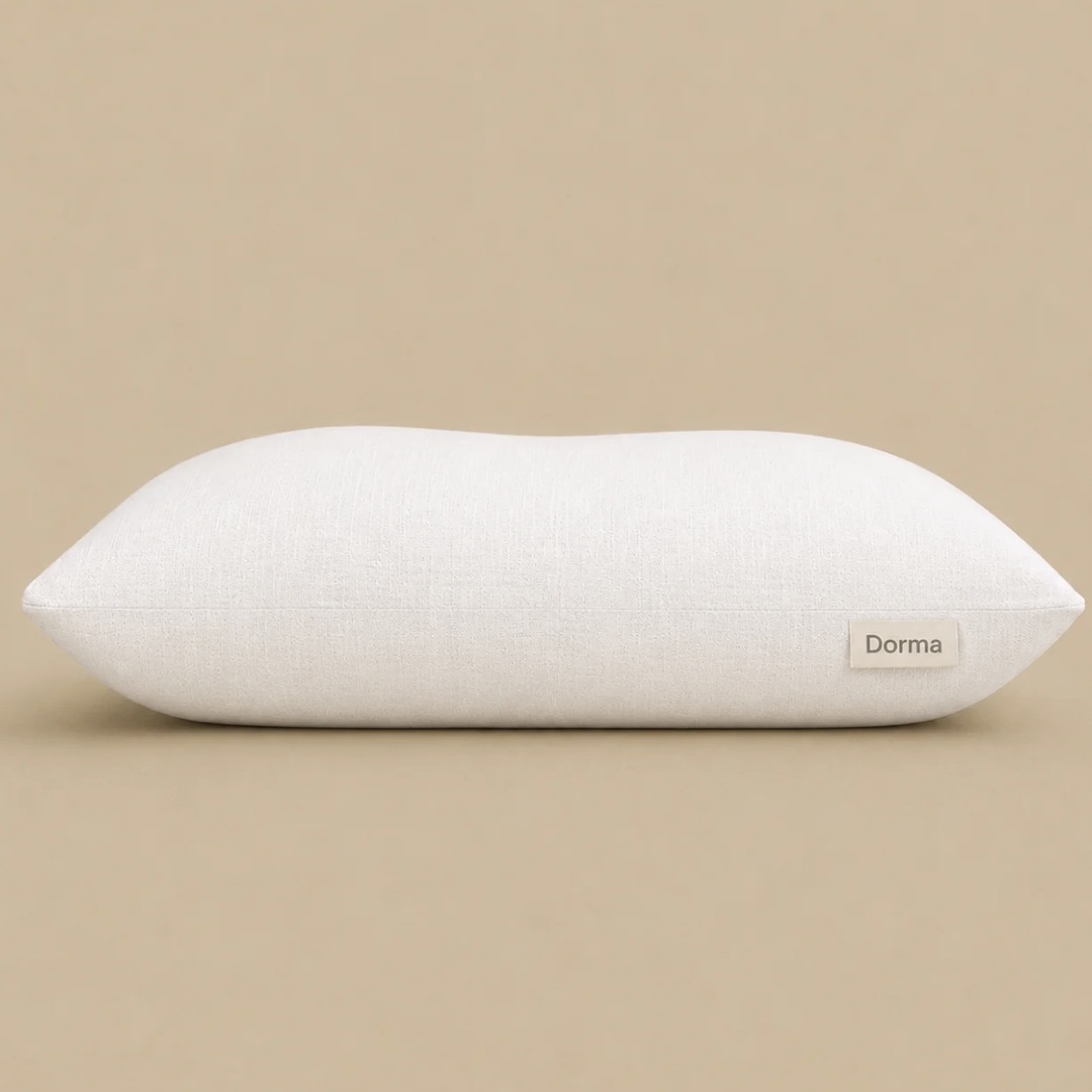 Almohada Dorma de funda color crema vista de frente sobre fondo beige, con la etiqueta de la marca en el costado