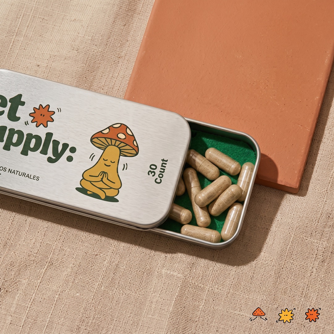 Lata de et supply abierta en primer plano sobre tela beige, con las cápsulas dentro y un hongo ilustrado en la tapa