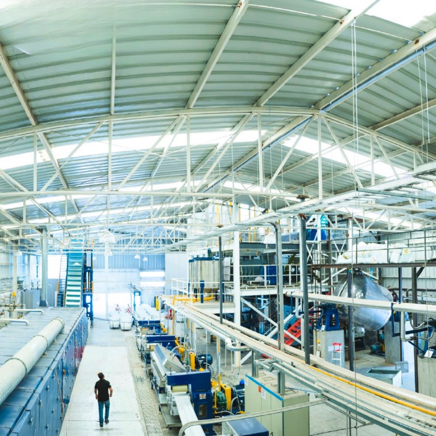 Planta de Technofibers en operación, con las líneas de producción de fibra vistas desde el pasillo elevado